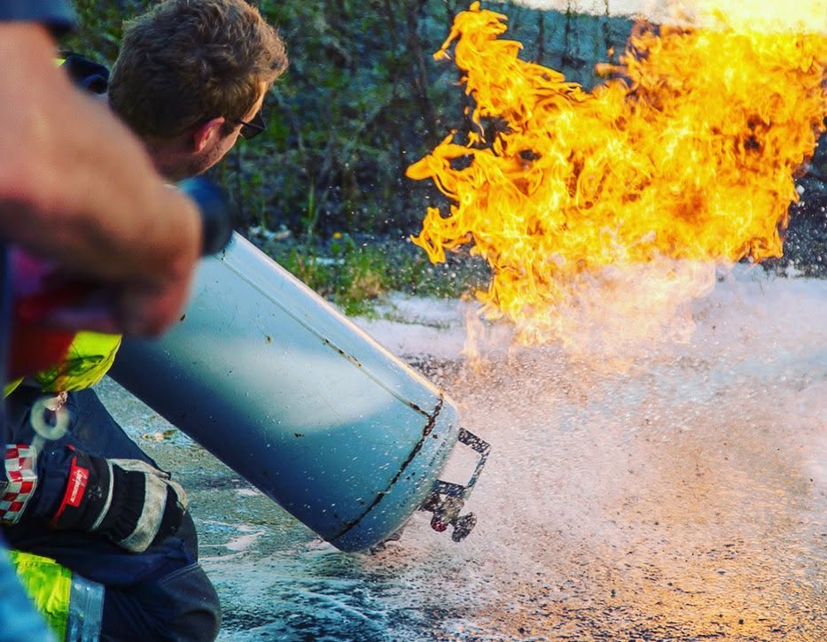 Brannkonstabel retter pulverslokker mot flammer under en øvelse
